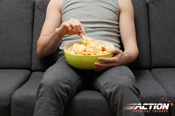 Man sitting on couch eating snack food.