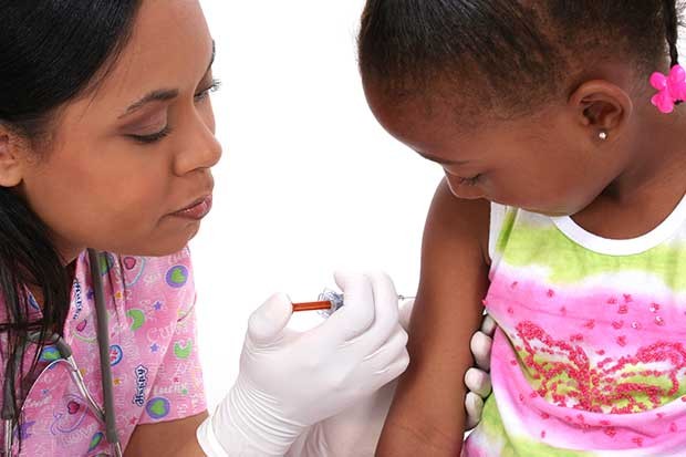 A small girl get s ashot from a doctor